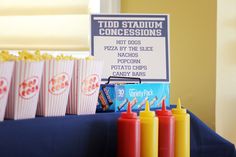 a table topped with lots of cups filled with popcorn