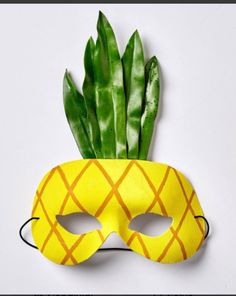 a yellow pineapple mask with green leaves