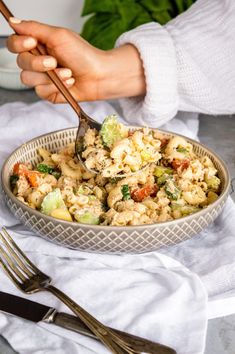 a person holding a spoon over a bowl of food