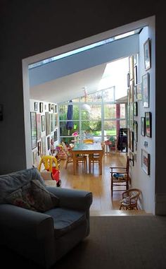 a living room filled with furniture and lots of pictures on the wall next to an open door