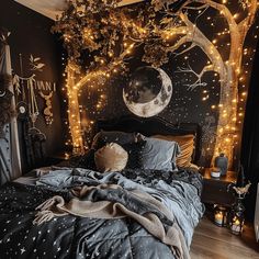 a bedroom decorated in black and white with lights on the tree, moon and stars