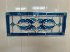 a blue stained glass window hanging on the wall