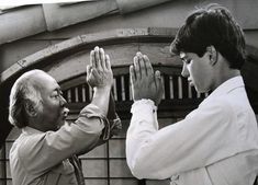 two men high fiving each other in front of a building