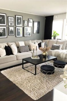 a living room filled with white furniture and pictures on the wall above the couches