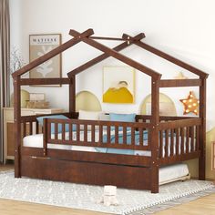 a child's bed with a wooden frame and canopy over it, sitting on a rug