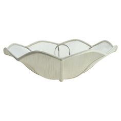 a white glass bowl with curved edges on a white background, it is shaped like a boat