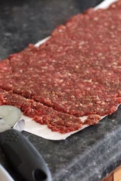 raw ground beef is being prepared on a cutting board