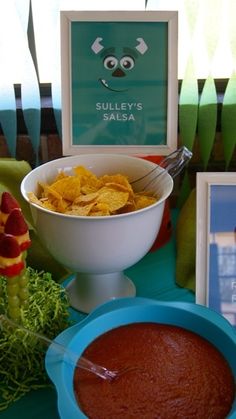 there is a bowl of salsa and chips on the table