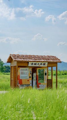 an outhouse in the middle of a grassy field