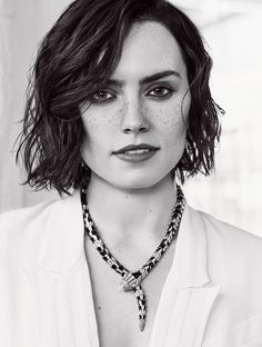 a woman with freckled hair is wearing a white shirt and black and white necklace