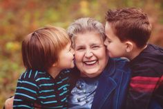 an older woman and two young boys are hugging each other while they both have their faces close together