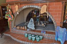 there is a fireplace with many shoes on the floor and clothes hanging up to dry