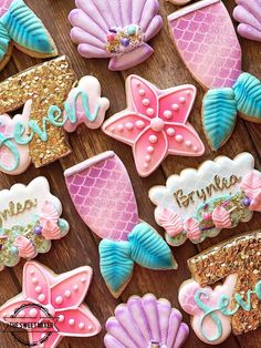 some decorated cookies are laying on a wooden table with the word mera written in cursive letters