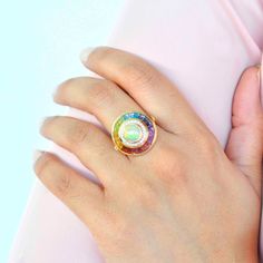 Elevate your style with the enchanting allure of our 18k gold Ethiopian white opal multicolor rainbow baguette circular diamond ring. This exquisite cocktail ring is a celebration of the opal's mesmerizing iridescence, embracing the ethereal play of bright fire colors that dance across its surface. Multicolor Opal Gemstone Ring, Fine Jewelry Multicolor Multi-stone Opal Ring, Multicolor Opal Round Ring, Multicolor Opal Ring, Multicolor Opal Multi-stone Rings, Elegant Multicolor Opal Ring, Multicolor Multi-stone Opal Ring, Rainbow Gemstones, Channel Set