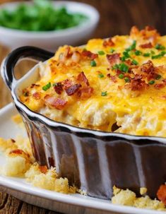 a casserole dish with bacon, cheese and green onions in it on a plate