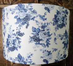 a blue and white floral lamp shade on a wooden table