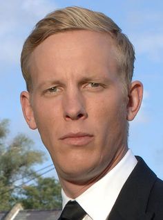 a man in a suit and tie looking at the camera