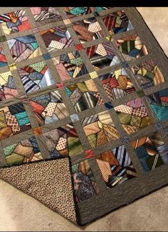 a multicolored quilt is laying on the floor with it's edges cut off