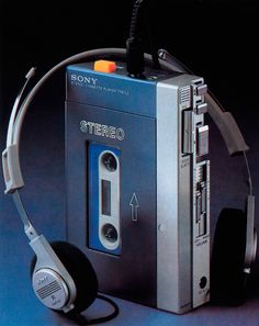 an old cassette player with headphones attached to it's earpieces, in front of a black background