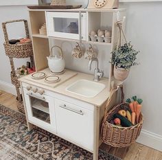 a toy kitchen with a sink, microwave and shelves