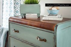 an old dresser with some books and a plant on top