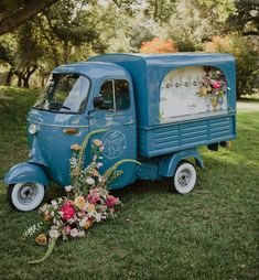 an old blue truck is decorated with flowers