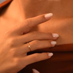 a woman's hand with a diamond ring on her left wrist and white nails