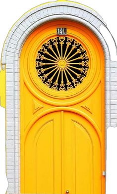 a yellow door with a circular window on it's side and an arch at the top