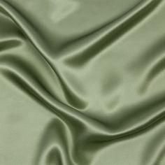 a close up view of a green silk fabric with very soft folds and smooth lines