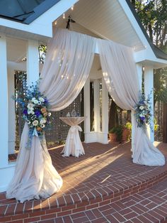 an outdoor wedding setup with drapes and flowers