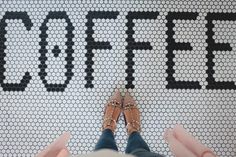 someone standing in front of a sign that says coffee