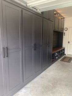 an empty garage with lots of gray cabinets and storage space on the wall, in front of a white door