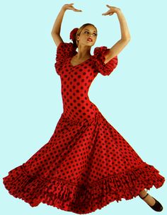 a woman in a red and black polka dot dress with her arms out, dancing