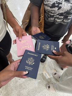 three people holding passport cards in their hands