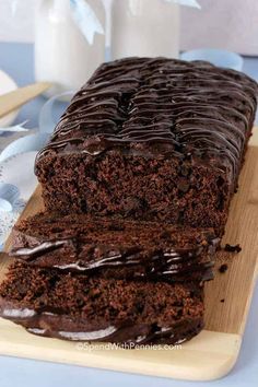 a loaf of chocolate cake sitting on top of a wooden cutting board