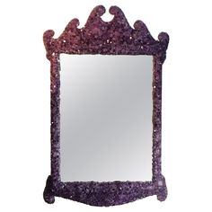 a purple mirror sitting on top of a white wall