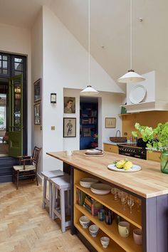 a kitchen with wooden floors and an island in front of the door that leads to another room