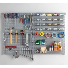 a peg board with tools hanging on it and a picture of the wall behind it