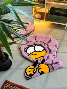 two rugs with cartoon characters on them sitting next to a potted palm tree