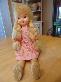 a doll sitting on top of a wooden table