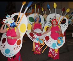 two women in costume holding paddles and standing next to each other