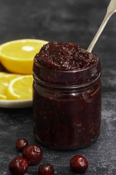 cranberry sauce in a glass jar next to sliced lemons