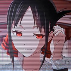 an anime character with black hair and red eyes talking on a cell phone in front of him