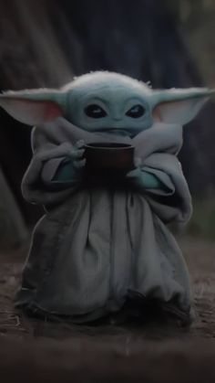 a baby yoda holding a tablet in its hands