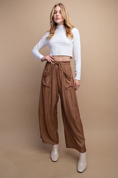 Step out in style with these semi-cropped pants! Crafted with a drawstring waist and front pocket detail, these pants offer an effortless yet sophisticated look. Finished in a toasted caramel hue, they pair perfectly with boots and a cropped sweater for a fashion-forward statement. Edgy Cropped Cotton Bottoms, Brown Cropped Pants With Pockets, Cropped Leg Pull-on Bottoms For Loungewear, Bohemian Brown Ankle-length Pants, Brown High-waisted Harem Pants With Pockets, Pocket Detail, Cropped Sweater, Drawstring Waist, Cropped Pants