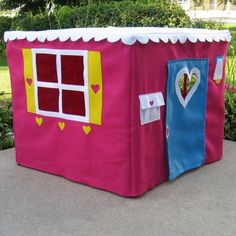 a pink play house with windows and hearts on it