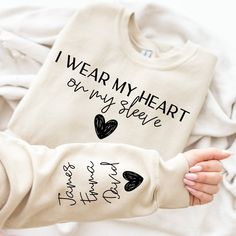 I Wear My Heart On My Sleeve Sweatshirt, Gift for Mum, Custom Mama Sweatshirt with Children Name on Sleeve, Mothers Day, Custom Gift Mom Sweatshirt, Hi! Welcome to the 💍 Lord Of The Shirt 💍 store.  We offer a wide range of unique designs tailored specifically for you. Please take a look at the other products in my shop! Our sweatshirts are made of a thick cotton and polyester blend that provides both comfort and style. There are no side seams and the air-jet yarn ensures a softer feel and less Heart On My Sleeve, Mama Svg, Letter Print Sweatshirt, Mama Shirts, Mama Sweatshirt, Mom Sweatshirt, Heart On, Look Plus, Plus Size Casual