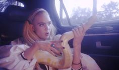 a woman sitting in the back seat of a car holding a banana