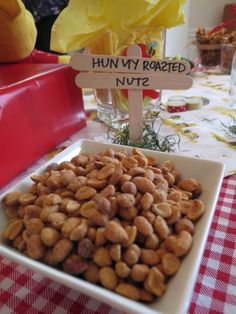 nuts in a bowl on a table with a sign that says hummy roasted nuts