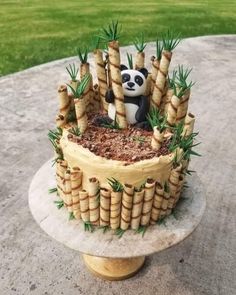 a cake decorated with bamboo sticks and a panda bear sitting on it's side